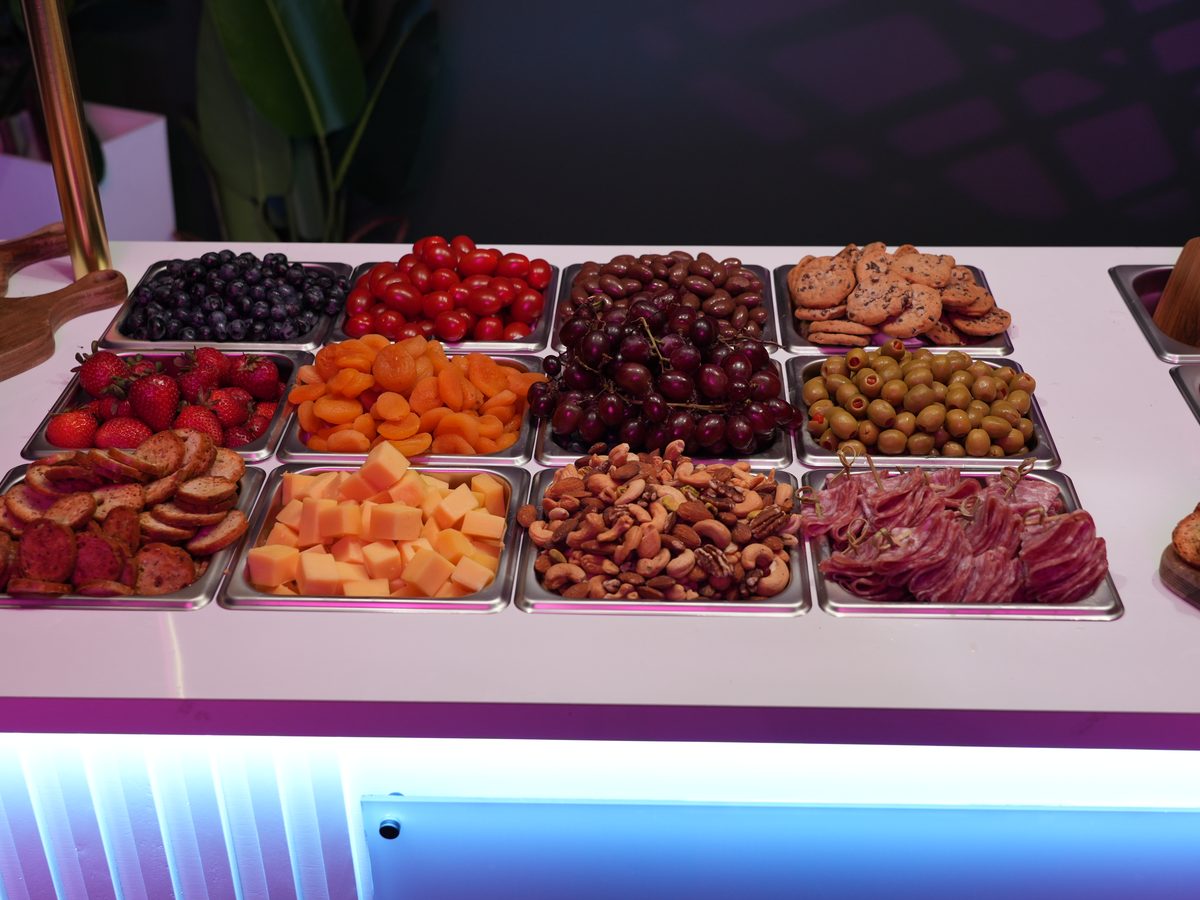 Grazing table spread with fruit, nuts, olives and cured meats
