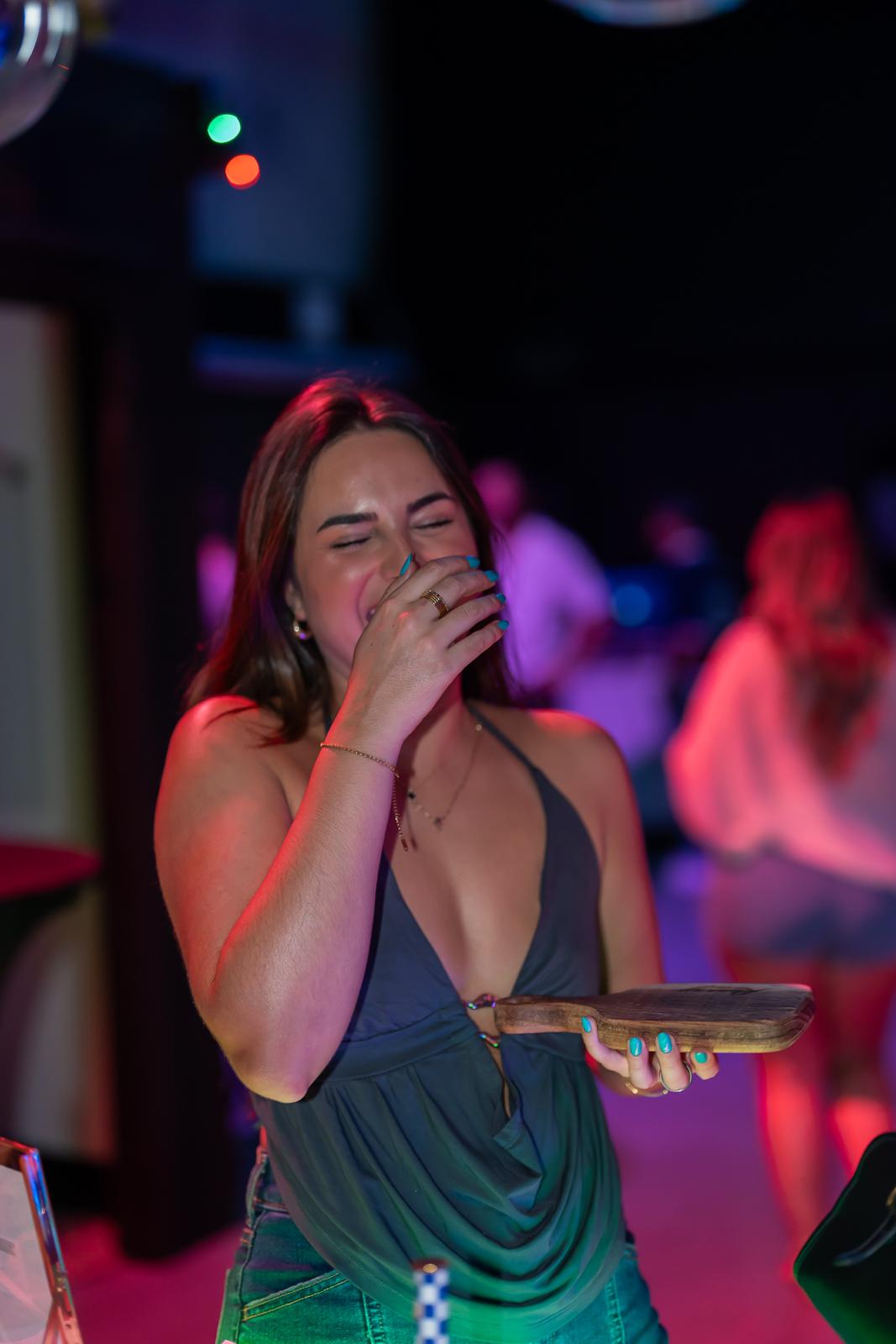 Guest laughing while holding her engraved Runway Bites board