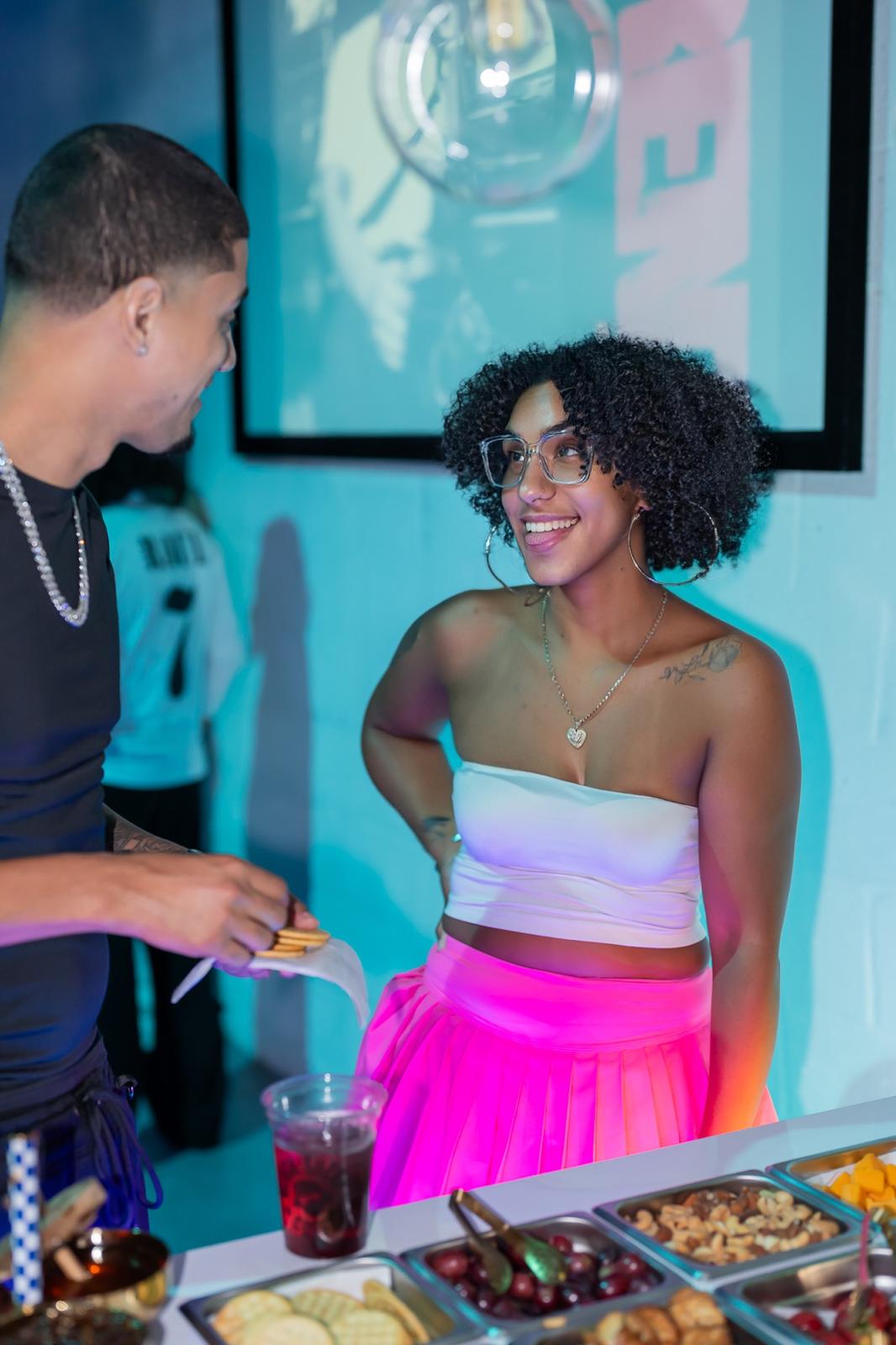 A Runway Bites host handing crackers to a guest at the grazing bar